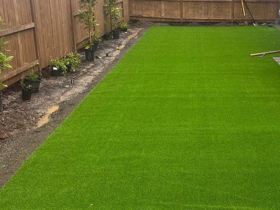 Artificial turf: a long synthetic turf backyard lawn inside a cedar fence