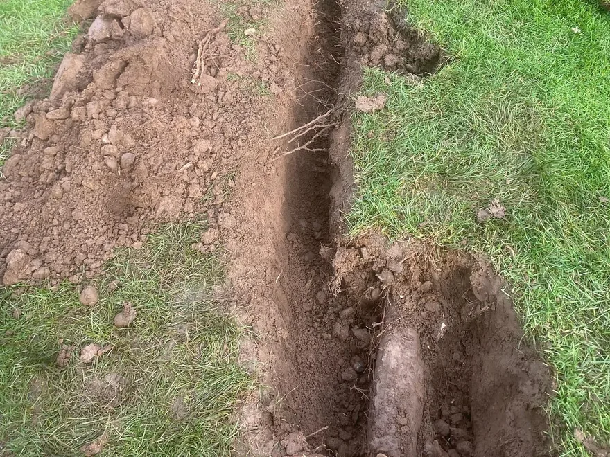 French drains: a narrow drain trench dug through a lawn