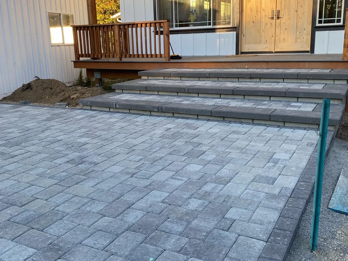 Paver patios: a large paver landing with block-cap steps leading up to a front porch