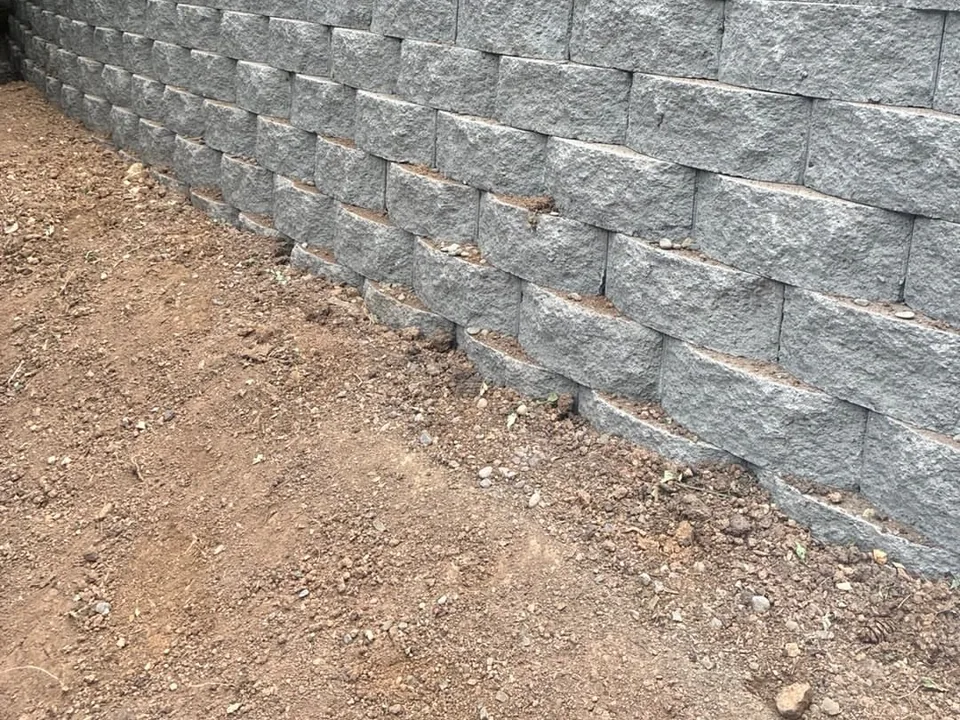 Retaining walls: a tall segmental block retaining wall along a graded slope