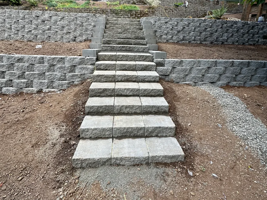 Retaining walls: terraced segmental block retaining walls with built-in block steps on a sloped backyard